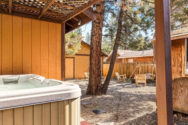 view of yard featuring a pergola, fence, and a hot tub