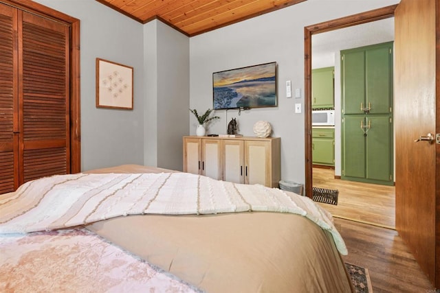 bedroom featuring a closet, wood finished floors, and wood ceiling