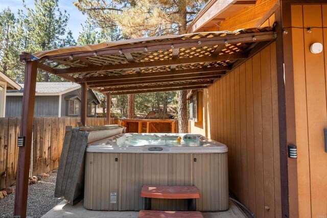 view of patio with fence and a hot tub