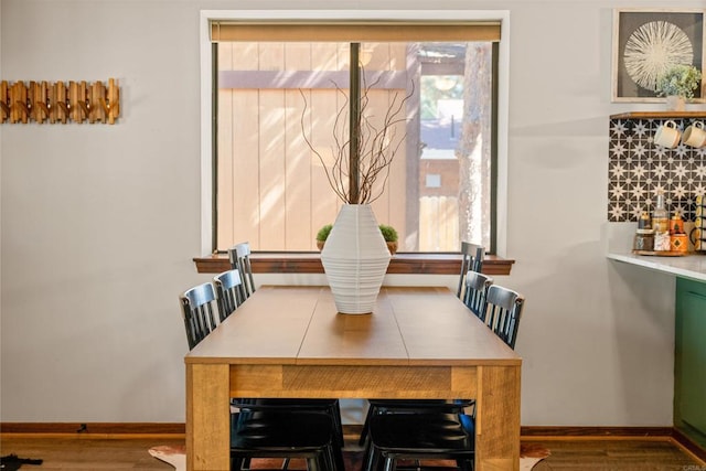 dining space featuring baseboards and wood finished floors