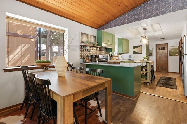 dining space featuring a tray ceiling, wood finished floors, wood ceiling, and baseboards