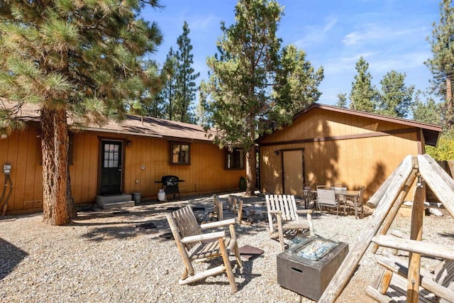 rear view of property with an outdoor fire pit and a patio