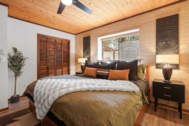 bedroom with a closet, wooden ceiling, ceiling fan, and wood finished floors