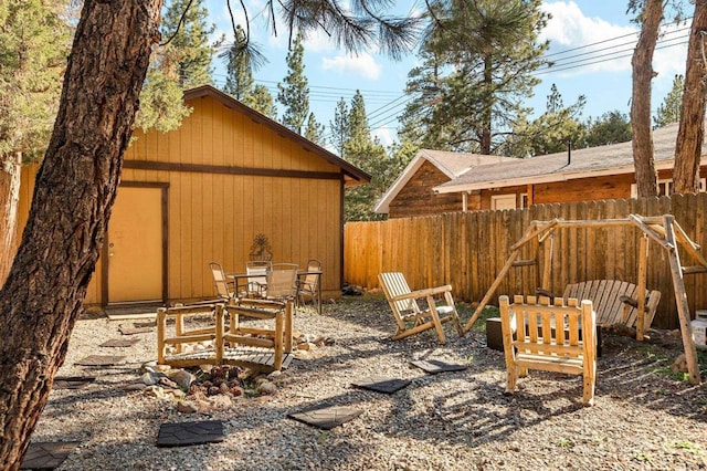 view of yard with fence, a patio, and an outbuilding