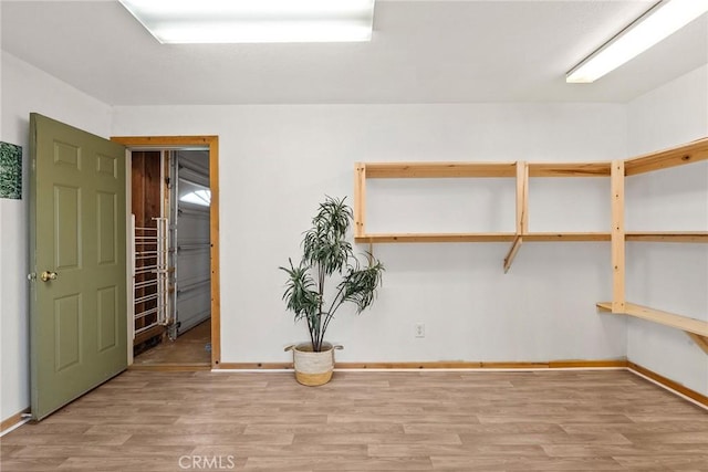 interior space featuring baseboards and wood finished floors