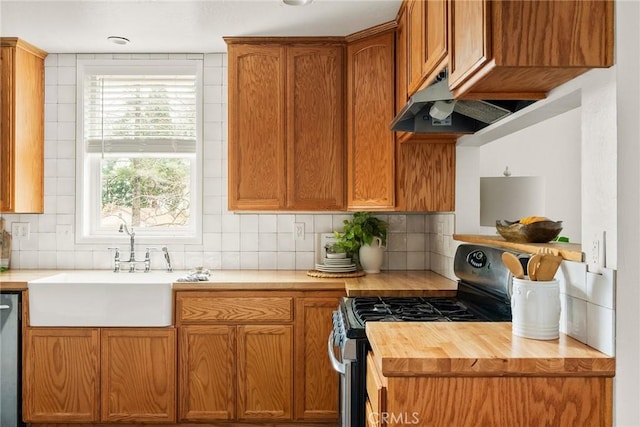 kitchen with butcher block countertops, a sink, stainless steel gas range, dishwasher, and under cabinet range hood