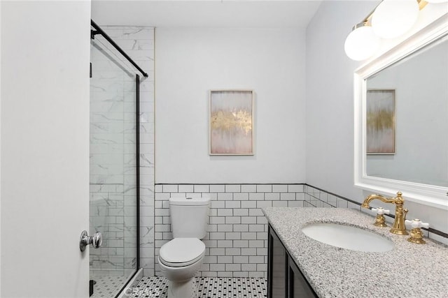 full bath with tile walls, a shower stall, toilet, and vanity