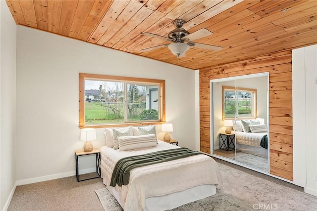 bedroom featuring wooden ceiling, carpet, baseboards, and a closet