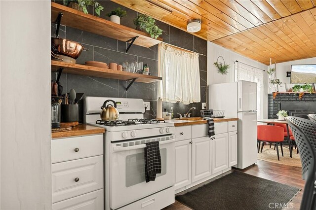 kitchen with white appliances, decorative backsplash, lofted ceiling, wooden ceiling, and white cabinetry