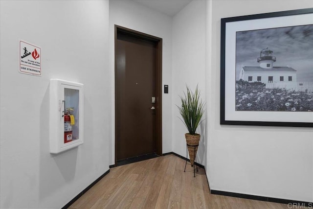 hallway featuring baseboards and wood finished floors