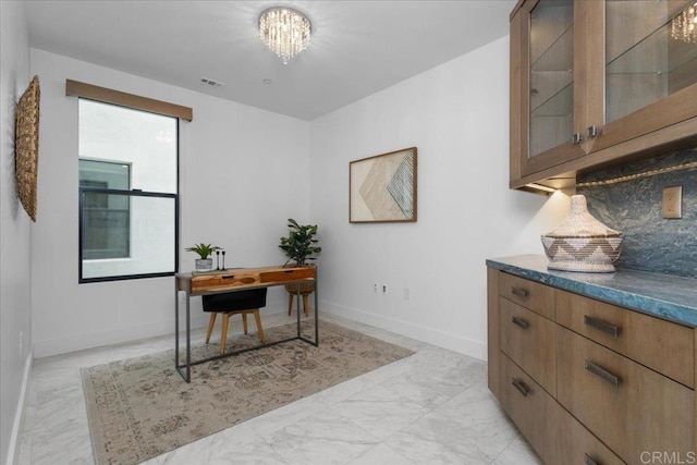 office with baseboards, visible vents, and a notable chandelier
