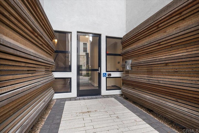 view of exterior entry featuring stucco siding