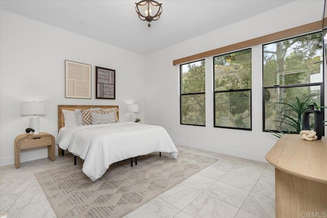 bedroom featuring marble finish floor and baseboards
