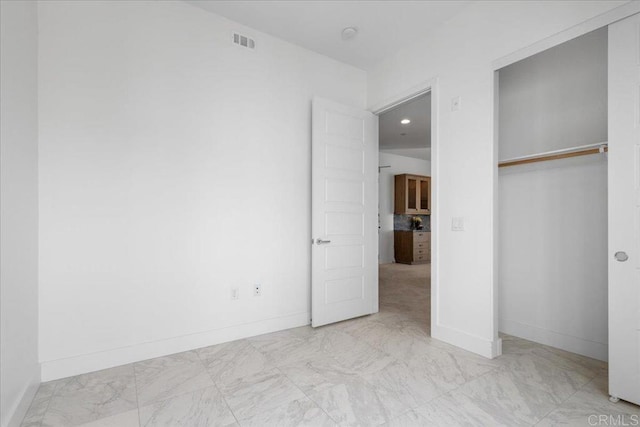 unfurnished bedroom with recessed lighting, a closet, marble finish floor, visible vents, and baseboards