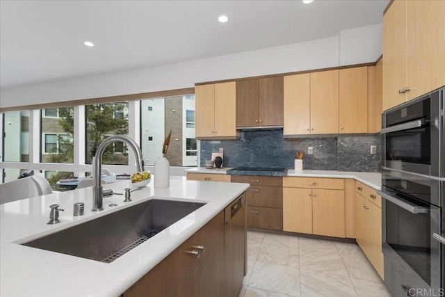 kitchen with recessed lighting, marble finish floor, a sink, and light countertops