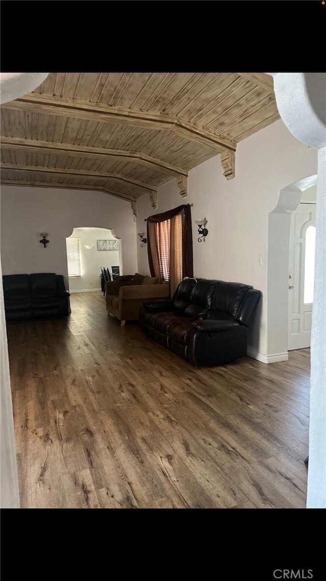 interior space featuring arched walkways, beamed ceiling, wood finished floors, and wood ceiling