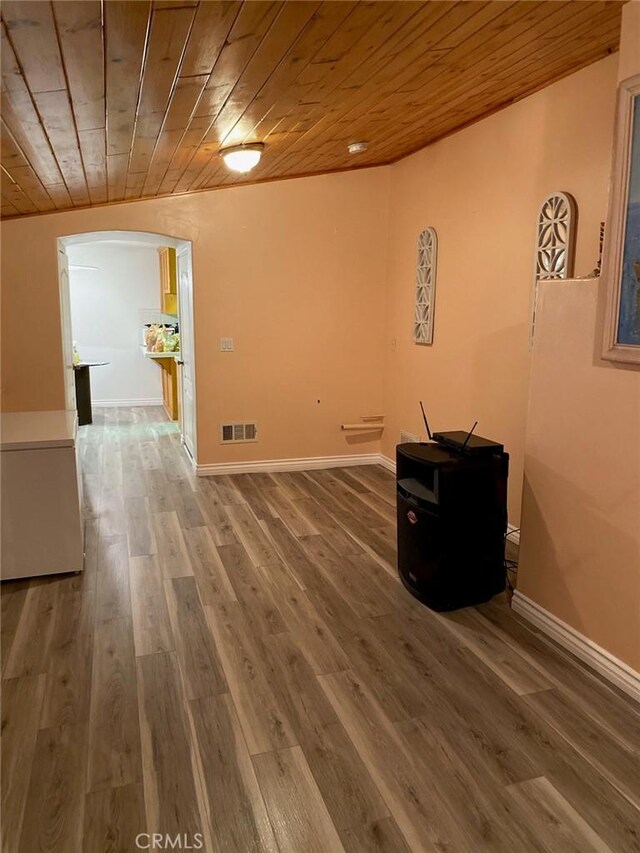 interior space with arched walkways, visible vents, wood finished floors, wooden ceiling, and baseboards