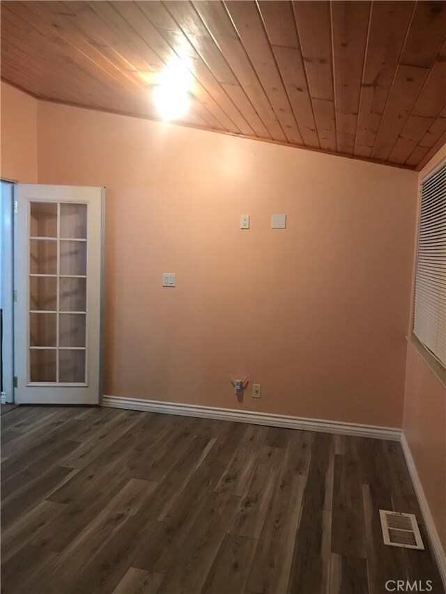 spare room with wooden ceiling, baseboards, visible vents, and dark wood-style flooring