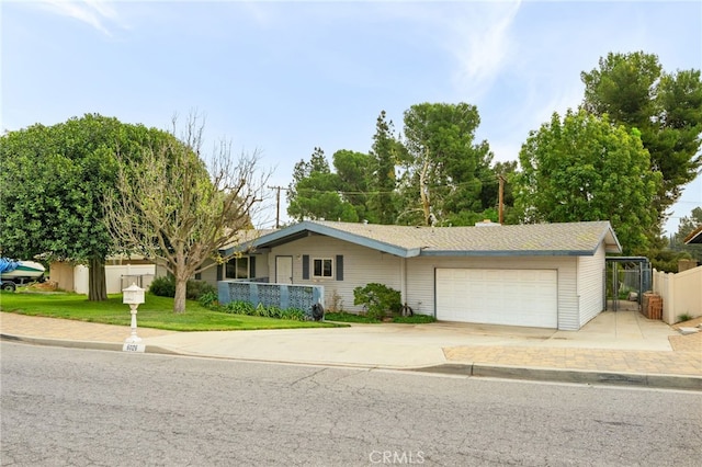 single story home with a garage, driveway, a front lawn, and fence