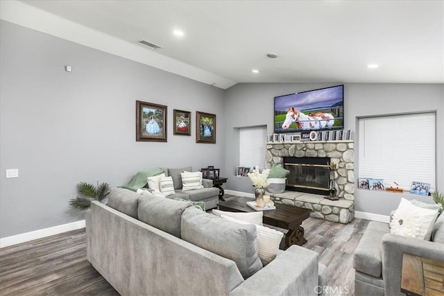 living room with a fireplace, lofted ceiling, visible vents, wood finished floors, and baseboards