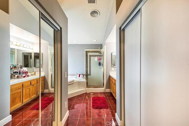 full bath featuring a garden tub, a stall shower, vanity, tile patterned flooring, and baseboards