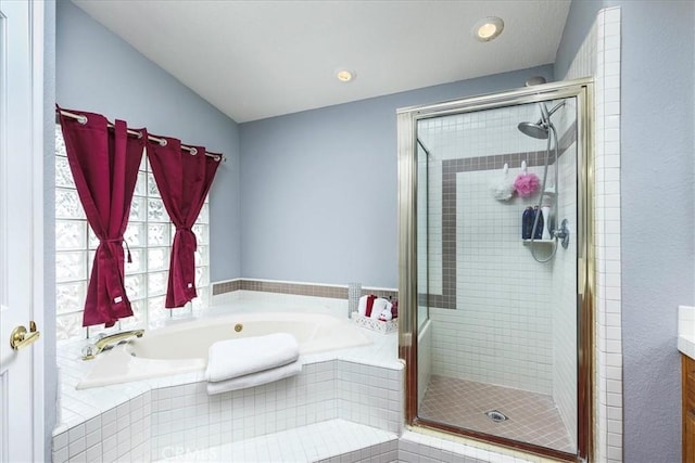 bathroom with a stall shower, a garden tub, vanity, and recessed lighting