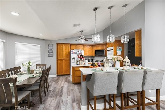 kitchen with white appliances, visible vents, brown cabinetry, light countertops, and light wood-style floors