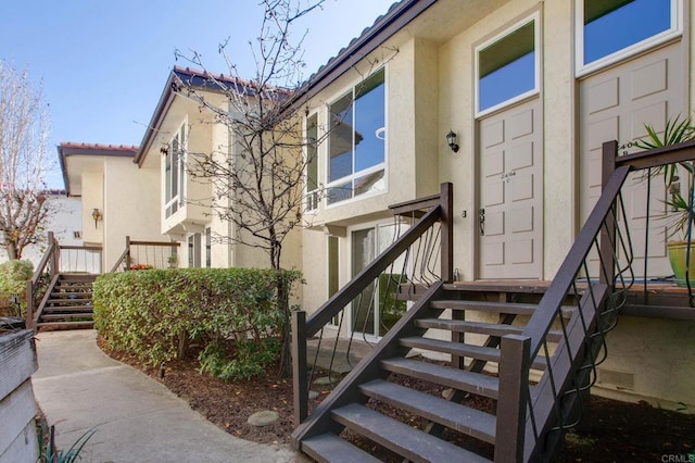 view of exterior entry featuring a tile roof and stucco siding