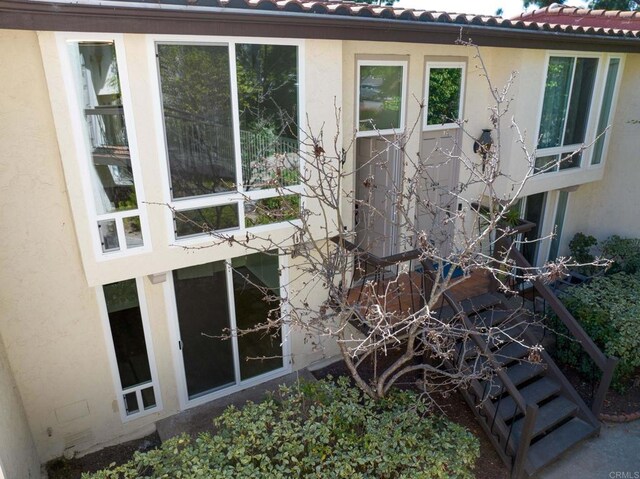 view of home's exterior with a tiled roof and stucco siding