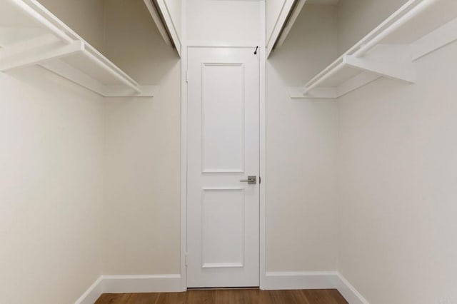 walk in closet with wood finished floors