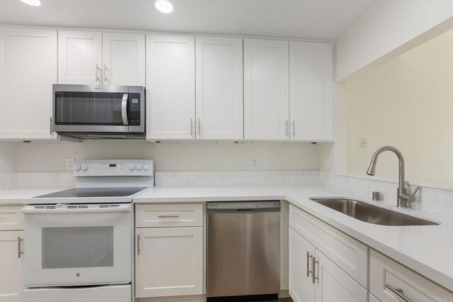 kitchen featuring stainless steel appliances, recessed lighting, a sink, and white cabinets