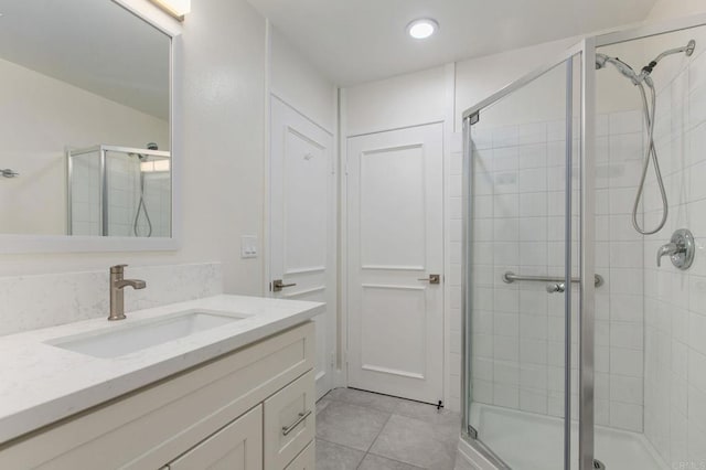 bathroom featuring tile patterned flooring, recessed lighting, vanity, and a shower stall