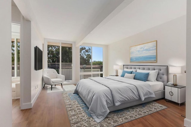 bedroom featuring baseboards, wood finished floors, access to outside, and beamed ceiling