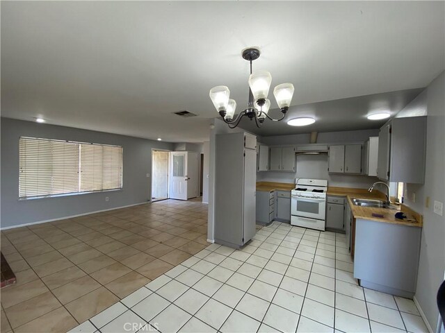 kitchen featuring open floor plan, light tile patterned floors, visible vents, and white range with gas cooktop