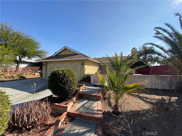 view of front of property with fence, driveway, an attached garage, and stucco siding