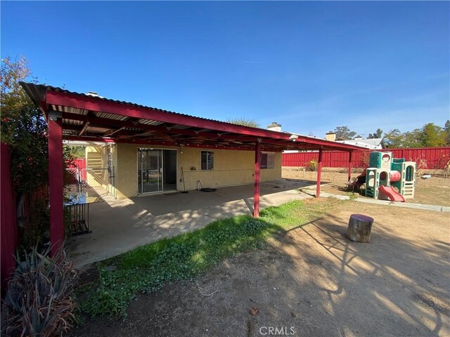 back of house featuring a patio area, fence, and stucco siding