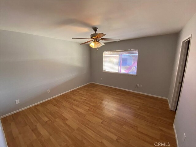 unfurnished bedroom with baseboards, a ceiling fan, and light wood-style floors