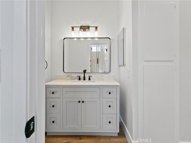 bathroom featuring baseboards, wood finished floors, and vanity