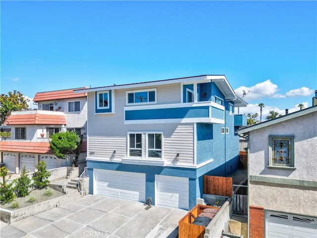 view of front of property featuring an attached garage, driveway, and stucco siding