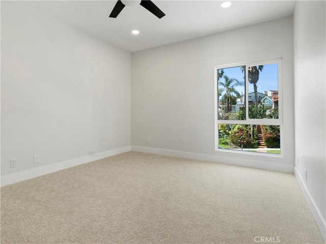 spare room featuring recessed lighting, baseboards, and light colored carpet