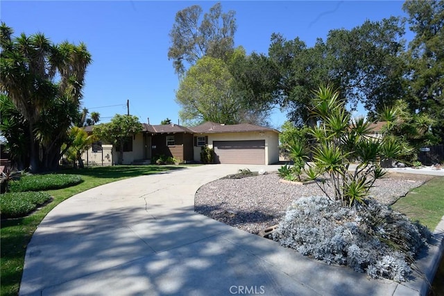 view of front facade with concrete driveway, an attached garage, and stucco siding