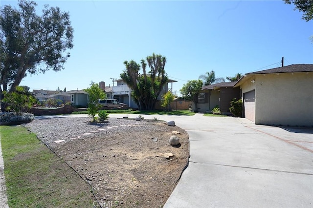 ranch-style home featuring a garage, concrete driveway, and stucco siding