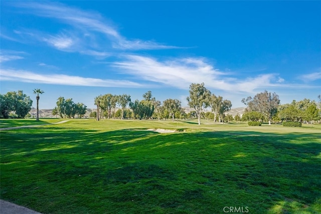 view of property's community with golf course view and a yard