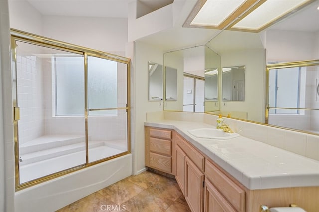 full bathroom featuring combined bath / shower with glass door, vanity, and a healthy amount of sunlight