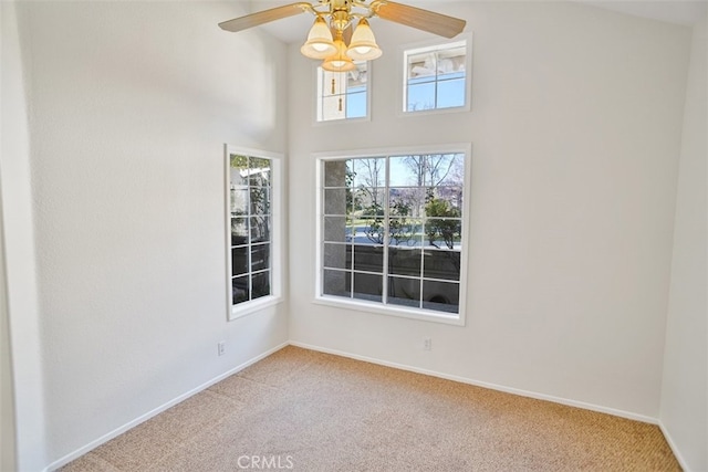 spare room with carpet, baseboards, and a ceiling fan