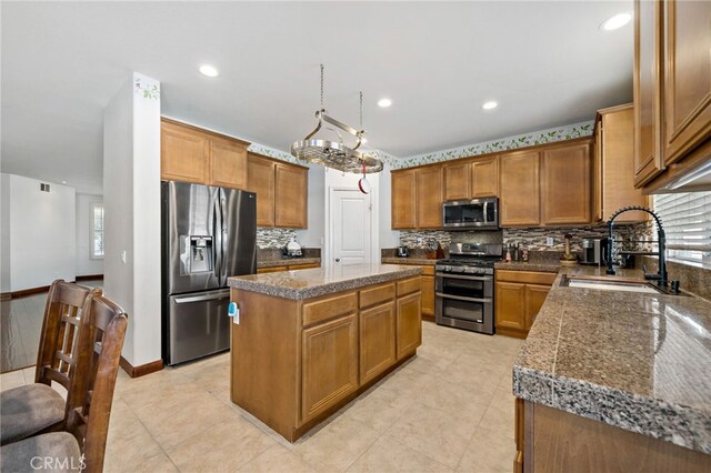 kitchen featuring a center island, stainless steel appliances, backsplash, a sink, and plenty of natural light