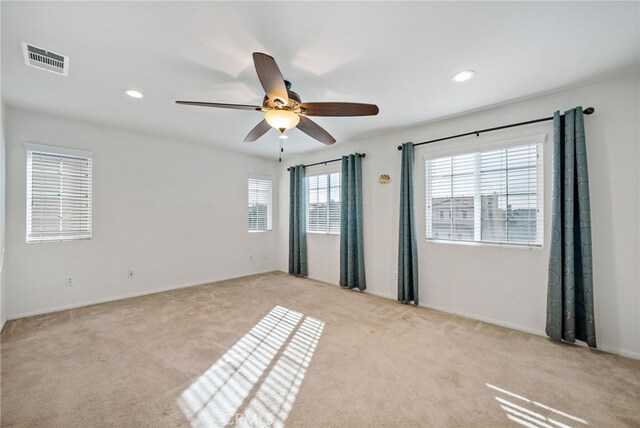 carpeted empty room with ceiling fan, visible vents, and recessed lighting