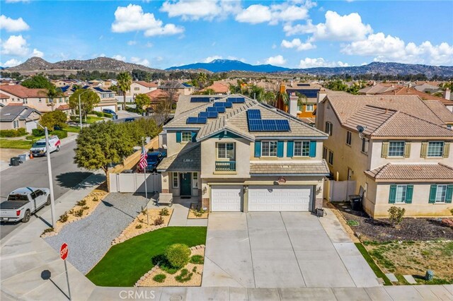 view of front of house featuring a garage, a residential view, fence, and a mountain view