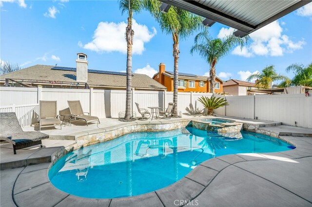 view of pool featuring a pool with connected hot tub, a fenced backyard, and a patio