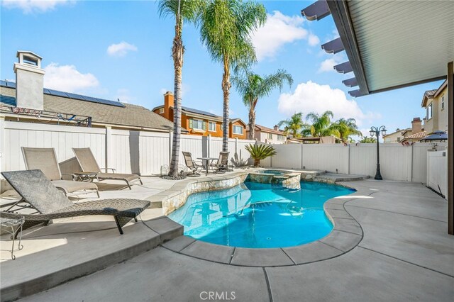 view of swimming pool with a pool with connected hot tub, a fenced backyard, and a patio